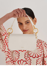 Profile view of model wearing the Oroton Liv Small Day Bag in Paper White and Pebble leather for Women