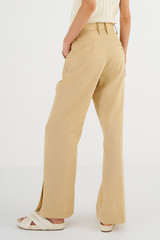 Profile view of model wearing the Oroton Split Hem Pant in Cane Sugar and 66% Viscose 34% Cotton for Women