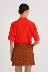 Profile view of model wearing the Oroton Short Lace Skirt in Tan and 100% Polyester for Women