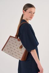 Profile view of model wearing the Oroton Lena Day Bag in Cognac and Oroton Signature Recycled Jacquard Fabric. Smooth Leather for Women