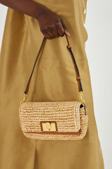 Profile view of model wearing the Oroton Kerr Collectable Small Day Bag in Natural/Brandy and Raffia for Women