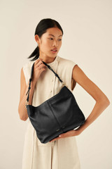 Profile view of model wearing the Oroton Tessa Hobo in Black and Soft Pebble Leather for Women