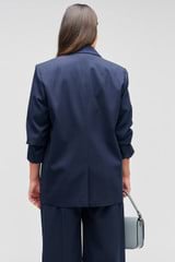 Profile view of model wearing the Oroton Single Breasted Blazer in North Sea and 98%  wool, 2% elastane for Women