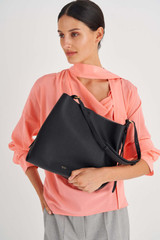 Profile view of model wearing the Oroton Margot Hobo in Black and Pebble Leather for Women