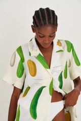 Profile view of model wearing the Oroton Summer Vegetable Camp Shirt in String and 100% Silk for Women