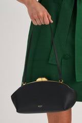 Profile view of model wearing the Oroton Meadow Clutch in Black and Smooth Leather for Women