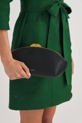 Profile view of model wearing the Oroton Meadow Clutch in Black and Smooth Leather for Women