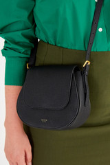 Profile view of model wearing the Oroton Margot Saddle Crossbody in Black and Pebble Leather for Women