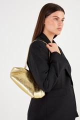 Profile view of model wearing the Oroton Meadow Metallic Clutch in Gold and Metallic Crinkle Leather for Women