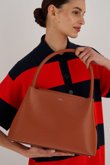 Profile view of model wearing the Oroton Muse Day Bag in Cognac and Saffiano / Smooth Leather for Women