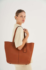 Profile view of model wearing the Oroton Lilly Shopper Tote in Cognac and Pebble Leather for Women