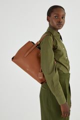 Profile view of model wearing the Oroton Margot Medium Day Bag in Whiskey and Pebble Leather for Women