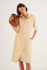 Profile view of model wearing the Oroton Wrap Utility Skirt in Creamed Honey and 58% Viscose 42% Linen for Women