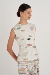 Profile view of model wearing the Oroton Spaced Label Shell Top in Soft Cream and 100% Silk for Women