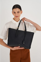 Profile view of model wearing the Oroton Margot Medium Zip Tote in Black and Pebble leather for Women