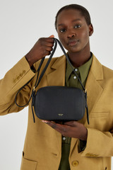 Profile view of model wearing the Oroton Margot Zip Around Crossbody in Black and Pebble leather for Women