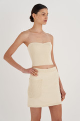 Profile view of model wearing the Oroton Short Knit Skirt in Vanilla Bean and 100% Cotton for Women
