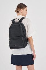 Profile view of model wearing the Oroton Lilly 15" Backpack in Black and Pebble leather/Nylon for Women