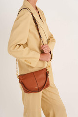 Profile view of model wearing the Oroton Lilly Zip Top Crossbody in Cognac and Pebble leather for Women
