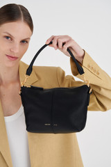 Profile view of model wearing the Oroton Lilly Zip Top Crossbody in Black and Pebble leather for Women