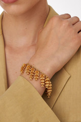 Profile view of model wearing the Oroton Riley Bracelet in Worn Gold and Brass Base With 18CT Gold Plating for Women