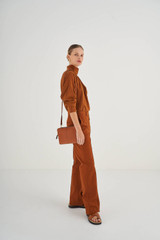 Profile view of model wearing the Oroton Lilly Double Zip Crossbody in Cognac and Pebble Leather for Women