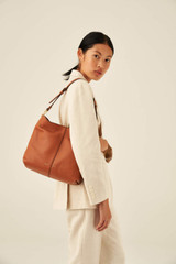 Profile view of model wearing the Oroton Tessa Hobo in Toffee and Soft Pebble Leather for Women