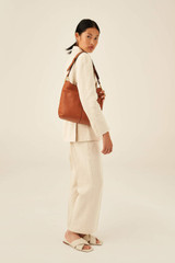 Profile view of model wearing the Oroton Tessa Hobo in Toffee and Soft Pebble Leather for Women