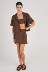 Profile view of model wearing the Oroton Scallop Wrap Skirt in Dark Chocolate and 100% Linen for Women
