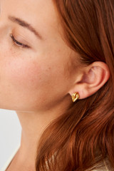 Profile view of model wearing the Oroton Luella Mini Earrings in Worn Gold and Brass Base With 18CT Gold Plating for Women