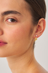 Profile view of model wearing the Oroton Sage Drop Earrings in Worn Gold and  for Women