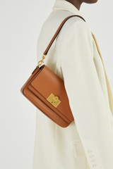 Profile view of model wearing the Oroton Kerr Small Day Bag in Brandy and Smooth Leather for Women