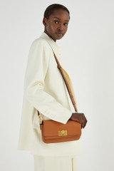Profile view of model wearing the Oroton Kerr Small Day Bag in Brandy and Smooth Leather for Women