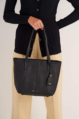 Profile view of model wearing the Oroton Lilly Small Shopper Tote in Black and Pebble Leather for Women