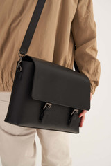 Profile view of model wearing the Oroton Oxley Satchel in Black and Pebble Leather for Men