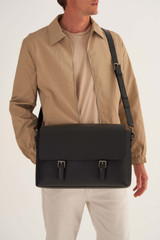 Profile view of model wearing the Oroton Oxley Satchel in Black and Pebble Leather for Men
