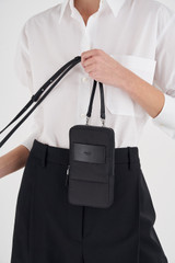 Profile view of model wearing the Oroton Tilly Phone Crossbody in Black and Nylon for Women
