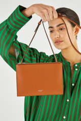 Profile view of model wearing the Oroton Muse Double Zip Crossbody in Cognac and Saffiano / Smooth Leather for Women