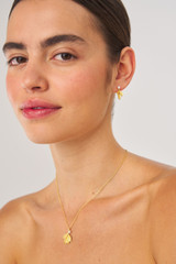 Profile view of model wearing the Oroton Sage Charm Necklace in Worn Gold and  for Women