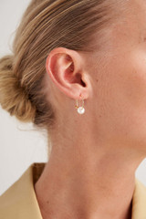 Profile view of model wearing the Oroton Skye Pearl Mini Hoops in Gold and Brass Base With 18CT Gold Plating for Women