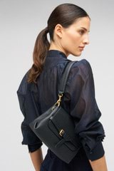 Profile view of model wearing the Oroton Margot Small Top Handle in Black and Pebble leather for Women