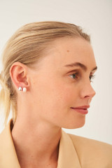 Profile view of model wearing the Oroton Violet Pearl Stud Set in Silver/White and Brass Base With Rhodium Plating for Women