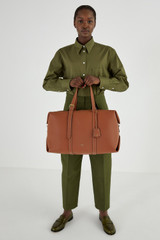 Profile view of model wearing the Oroton Margot Weekender in Whiskey and Pebble Leather for Women