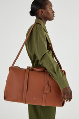 Profile view of model wearing the Oroton Margot Weekender in Whiskey and Pebble Leather for Women