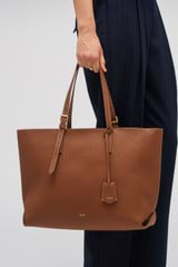 Profile view of model wearing the Oroton Margot Medium Zip Tote in Whiskey and Pebble Leather for Women