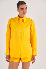 Profile view of model wearing the Oroton Poplin Long Sleeve Shirt in Marigold and 100% Cotton for Women