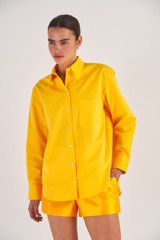 Profile view of model wearing the Oroton Poplin Long Sleeve Shirt in Marigold and 100% Cotton for Women