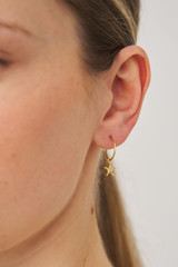 Profile view of model wearing the Oroton Starfish Hoops in Worn Gold/Clear and Brass base metal with precious metal plating for Women