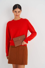 Profile view of model wearing the Oroton Margot Medium Pouch in Whiskey and Pebble Leather for Women