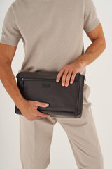 Profile view of model wearing the Oroton Lucas 13" Satchel in Chocolate/Black and Pebble Leather for Men